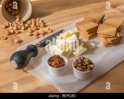 La fase di preparazione della tipica torta fatta in casa con il burro di cacao, zucchero e biscotti sbriciolati Foto Stock