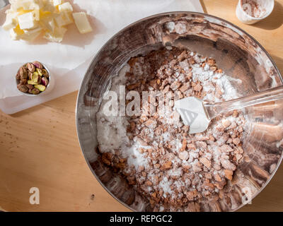 La fase di preparazione della tipica torta fatta in casa con il burro di cacao, zucchero e biscotti sbriciolati Foto Stock