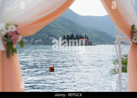 Arco di nozze decorata con fiori e panno per la cerimonia vicino al mare Foto Stock