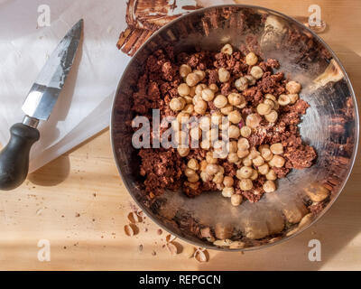 La fase di preparazione della tipica torta fatta in casa con il burro di cacao, zucchero e biscotti sbriciolati Foto Stock