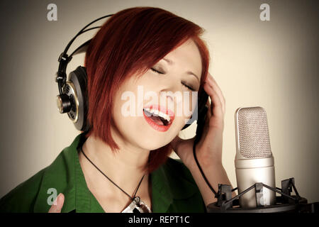 Cantante femminile con le cuffie la registrazione in studio Foto Stock