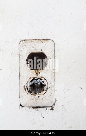 Close-up di vecchio e di colore marrone e bianco presa di corrente elettrica a muro bianco sulla parete di legno all'interno di un vecchio fienile Foto Stock