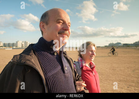 Coppia senior di camminare sulla spiaggia in tempo di primavera Foto Stock