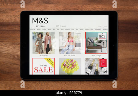 Il sito web di Marks & Spencer è visto su un tablet iPad, il quale è appoggiato su un tavolo di legno (solo uso editoriale). Foto Stock