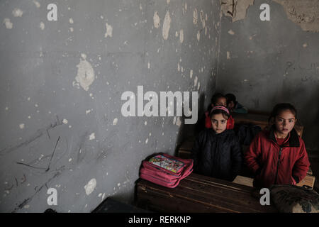 23 gennaio 2019, Siria, Jisr al-Shughur: siriana bambini sedersi all'interno di una classe del danneggiato al Kefir scuola a Jisr al-Shughur nelle mani dei ribelli Idlib provincia. Più di 200 studenti sono ancora andando a scuola nonostante la devastazione causata dalle incursioni effettuate dal governo siriano tra il 2015 e il 2016. Foto: Anas Alkharboutli/dpa Foto Stock