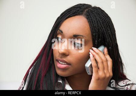 Giovane e bella di carnagione scura la donna a parlare su un telefono mobile Foto Stock