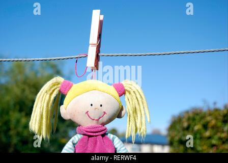 Un bambino giocattolo morbido appeso sulla linea di lavaggio a secco dopo essere stato lavato Foto Stock