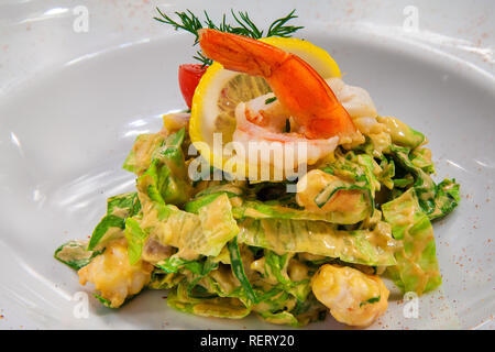 Cocktail con insalata di lattuga gamberi con una fettina di limone e un ciuffo di aneto fresco con salsa di paprika Foto Stock