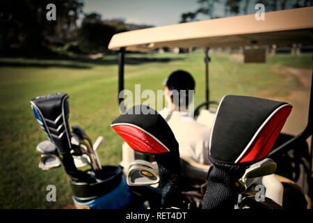 Club di golf all'interno di una sacca da golf nella parte posteriore di un carrello da golf in un campo da golf. Foto Stock