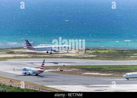 Montego Bay, Giamaica - 03 Luglio 2015: American Airlines aerei di atterraggio e un altro attende di discostarsi con Delta successivo in linea, a Sangster International Foto Stock