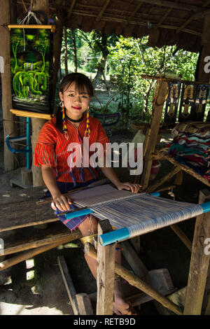 Ragazza che fa gli articoli in Hmong Thailandia tessendo tessuto perline di filato grazioso guardando ragazza pigtail rosso top villaggio felice intelligente guardare giovane frangia capelli Foto Stock