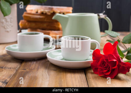 Cialde belghe per la prima colazione per due. I dolci fatti in casa e un mazzo di rose rosse sul tavolo. Delizioso pranzo romantico. Foto per il giorno di San Valentino Foto Stock