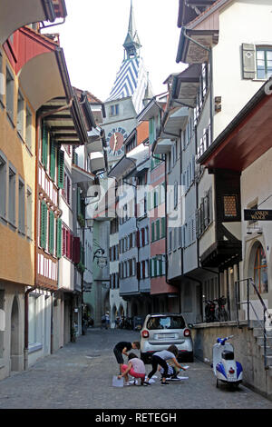 Svizzera Canton Zugo Zugo Zuger svizzero vedere il Lago di Zugo nel Altstadt giovani figli raccolgono documenti in strada Foto Stock