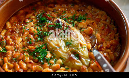 Nazionale serba piatto di cucina fagioli al forno o Prebranac servita con paprica verde e prezzemolo in una pentola di terracotta Foto Stock