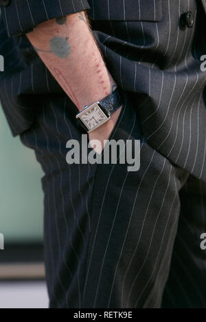 Milano, Italia - 14 gennaio 2019: Uomo con Cartier orologio con coccodrillo nero cinturino pelle e abito gessato prima di Emporio Armani fashion show, Mila Foto Stock