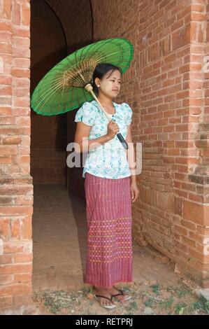 Giovane donna birmana con un ombrellone verde, Bagan, Myanmar Foto Stock