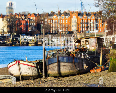 Barche ormeggiate a bassa marea sul fiume Tamigi a Wandsworth - il sud ovest di Londra, Inghilterra Foto Stock