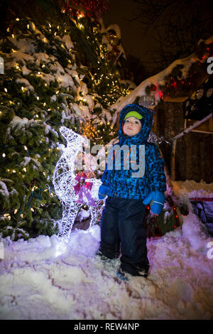 Carino baby boy nel villaggio di Babbo Natale Foto Stock