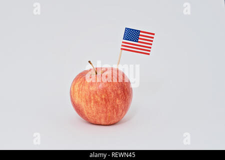 Ripe rosso apple e piccola bandiera americana crostino su sfondo bianco. Biglietto di auguri per la celebrazione del Giorno del Presidente in America concept Foto Stock