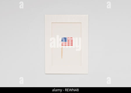 Bandiera in miniatura di America USA sul telaio bianco su sfondo chiaro. Biglietto di auguri per la celebrazione del Giorno del Presidente in America, giorno di indipendenza concep Foto Stock