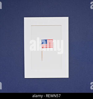 Bandiera in miniatura di America USA sul telaio bianco su sfondo blu. Biglietto di auguri per la celebrazione del Giorno del Presidente in America, giorno di indipendenza concept Foto Stock