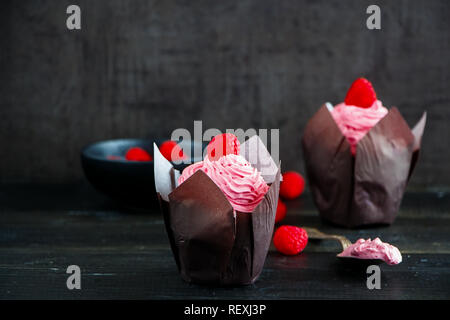 Tortini di rosa. Tortini di glassa decorata con lamponi freschi e crema di formaggio Foto Stock