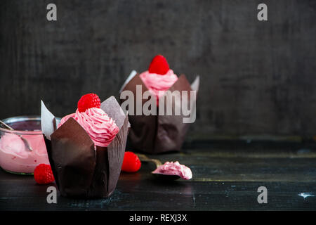 Deliziose tortine. Tortini di glassa decorata con un fresco e lampone e rosa di crema di formaggio Foto Stock