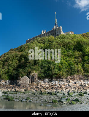 Le Mont Saint Michelle (Francia) in una giornata di sole in estate, la bassa marea, vista dal mare Foto Stock