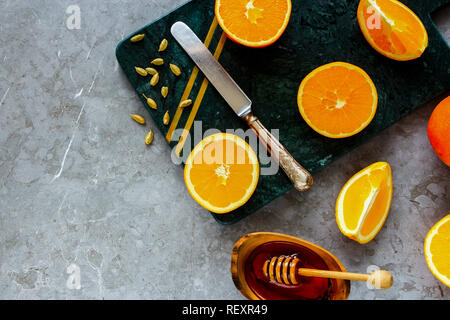 Rendendo naturale bevanda calda. Lay piatto di arance, miele e spezie. Bevande sane Foto Stock