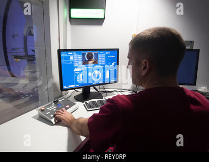 Il radiografo David Kirk dimostra la sala di controllo del nuovo centro di terapia Proton Beam dell'NHS presso l'ospedale Christie di Manchester, mentre Mason Kettley (non raffigurato), di 15 anni, che ha un raro tumore cerebrale, si prepara a sottoporsi al trattamento leader mondiale. Foto Stock