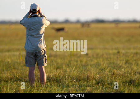 Il binocolo sono utili per cercare gli animali quando in safari Bangweulu, Zambia. Foto Stock