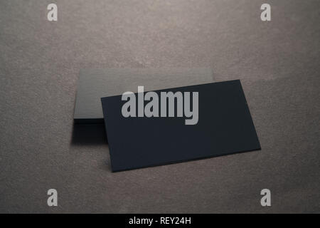 Foto di black blank business cards su uno sfondo nero. Modello per ID. Vista superiore Foto Stock