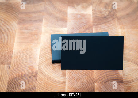 Foto di black blank business cards su sfondo di legno. Modello per ID. Vista superiore Foto Stock