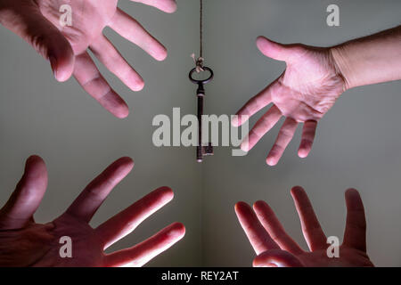 Persone di raggiungere le mani per chiave vintage appeso a una stringa. Il successo aziendale libertà concetto concetto di aspirazioni e di conseguimento e incentive Foto Stock