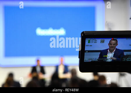 Risparmiare denaro esperto Martin Lewis (visto su un schermo della fotocamera) nel corso di una conferenza stampa congiunta con Facebook presso la sede centrale di Facebook a Londra. Foto Stock