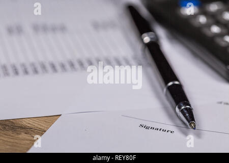 Penna a sfera, calcolatrice e Business Firma documento contrattuale sulla scrivania Foto Stock