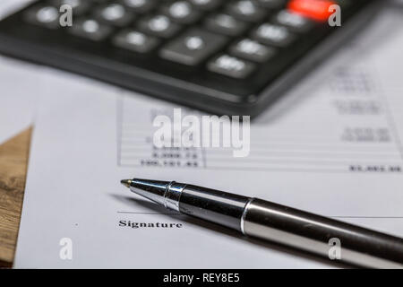 Penna a sfera e calcolatrice giacciono su Business Firma documento contrattuale Foto Stock