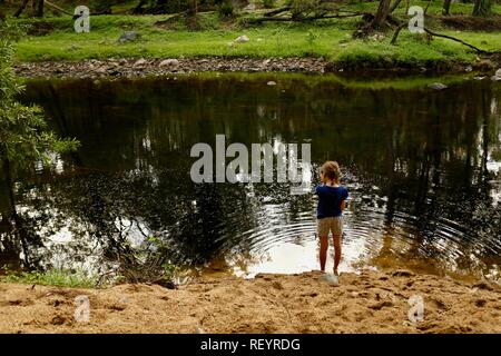 I bambini a piedi lungo una trazione a quattro ruote motrici via attraverso una foresta, Mia Mia la foresta di stato, Queensland, Australia Foto Stock