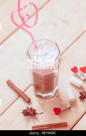 Caffè con latte in un bicchiere con un tubo di rosa. Le bevande Foto Stock