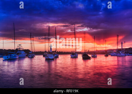 Yachts galleggianti in marina protetta di Wollongong cittadina porto dietro frangiflutti parete in pietra arenaria e due fari. Foto Stock