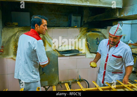 YAZD, IRAN - 18 ottobre 2017: i fornai rendere i pezzi di impasto per la preparazione della pasta in piccola panetteria di quartiere Fahadan, il 18 ottobre a Yazd Foto Stock
