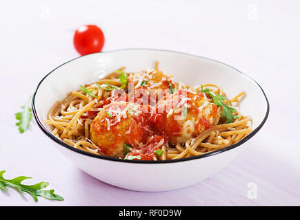 La pasta italiana. Spaghetti con le polpette di carne e formaggio parmigiano nella ciotola sulla luce legno rustico sfondo. La cena. Slow food concept Foto Stock