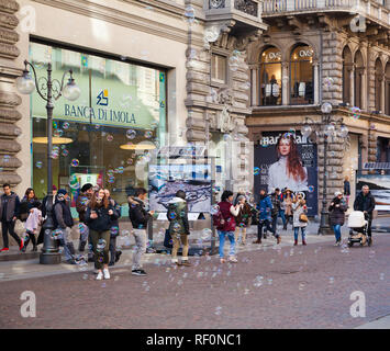 Milano, Italia - 19 Gennaio 2018: i turisti a piedi sulla via di Milano con un sacco di colorate bolle di sapone Foto Stock