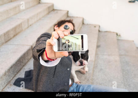 Il concetto di stile di vita. Uomo che fa un selfie con il suo cane. Foto Stock