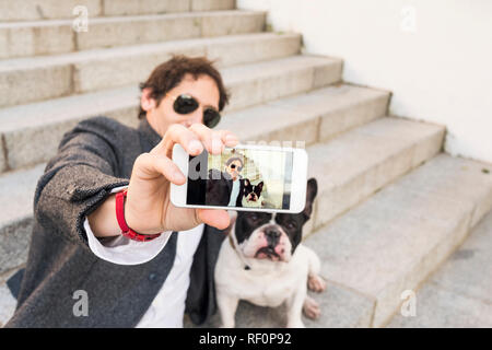 Il concetto di stile di vita. Uomo che fa un selfie con il suo cane. Foto Stock