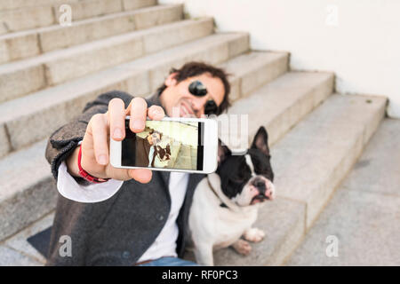 Il concetto di stile di vita. Uomo che fa un selfie con il suo cane. Foto Stock