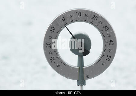 Termometro da giardino su una coperta di neve prato mostra una temperatura appena al di sotto di zero gradi centigradi Foto Stock