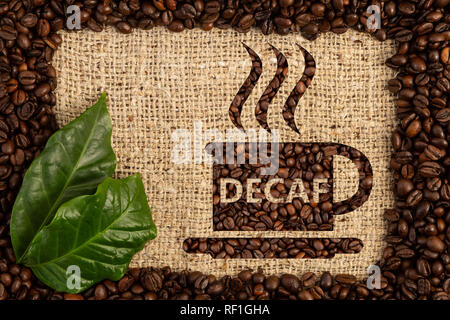 Tazza di caffè decaffeinato con testo scritto come aroma di no-caffeina bevanda calda sparsi all'interno dei chicchi di caffè telaio su tela marrone sfondo sacchetto Foto Stock