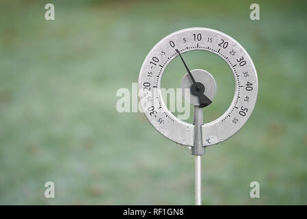 Giardino circolare termometro che mostra una temperatura di zero gradi centigradi con il ghiaccio su di essa lo scongelamento. Foto Stock