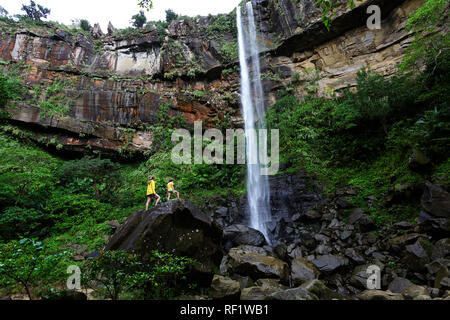 La madre e il figlio in piedi sul big rock a cascata, isola Iriomote, Giappone Foto Stock